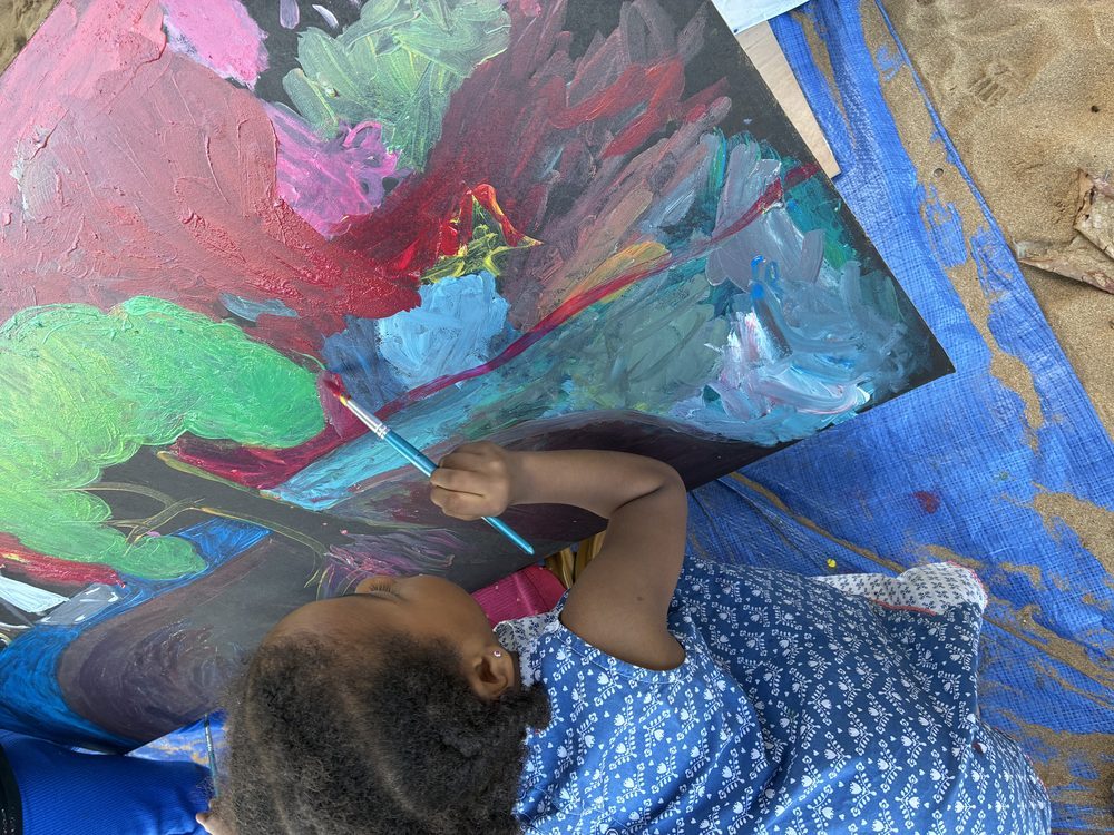 Petite fille peignant sur toile noire